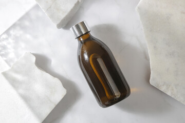 Brown glass cosmetic bottle on marble background