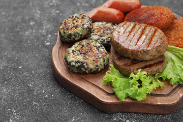 Different tasty vegan meat products and lettuce on grey table, closeup. Space for text
