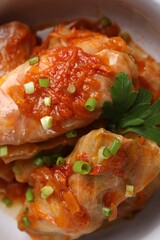 Delicious stuffed cabbage rolls cooked with homemade tomato sauce in bowl, closeup