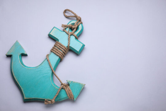 Wooden anchor figure on light background, top view. Space for text