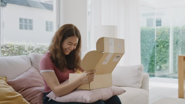 Asia people young Gen Z woman smile open unbox unpack parcel box goods carton packaging happy joy face. Omni channel enjoy buy gift order postal at retail online shop store send courier home service.