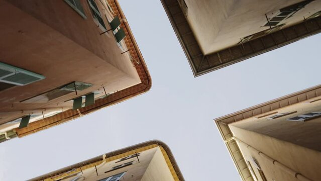 Worms eye slow motion shot of pigeon fly over old town of Nice in spring