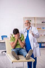 Obraz premium Young male patient visiting old male doctor in vaccination conce