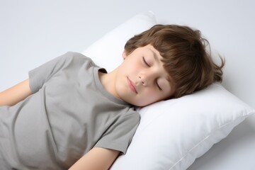 Fototapeta na wymiar a cute young boy child sleeps on a white pillow, isolated on white background, studio photo. generative ai