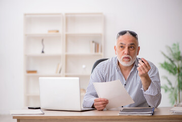 Old male employee working in the office