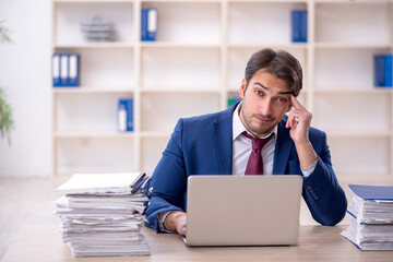 Fototapeta premium Young male employee and too much work in the office