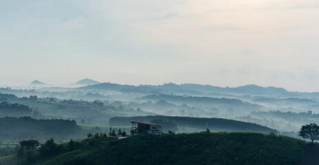 House on hill. Mountain farm house with foggy valley and distant mountains on horizon. Wonderful...