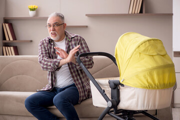 Old man looking after newborn at home