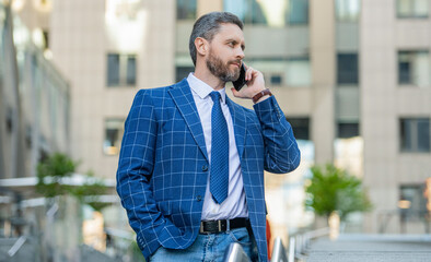 confident businessman has phone call outdoor. businessman having phone call