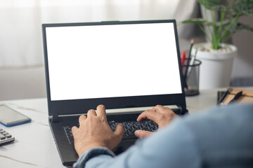 man's hands working on laptop in front of white