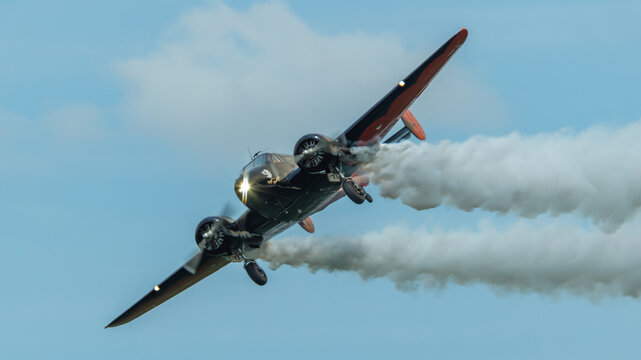Beech 18 approaches in a right bank with gear extended and smokecoming from both engines