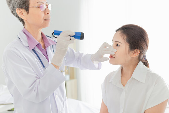 doctor use flashlight screening conjunctivitis patient, asian patient has red eyes and feeling pain, infection eye 