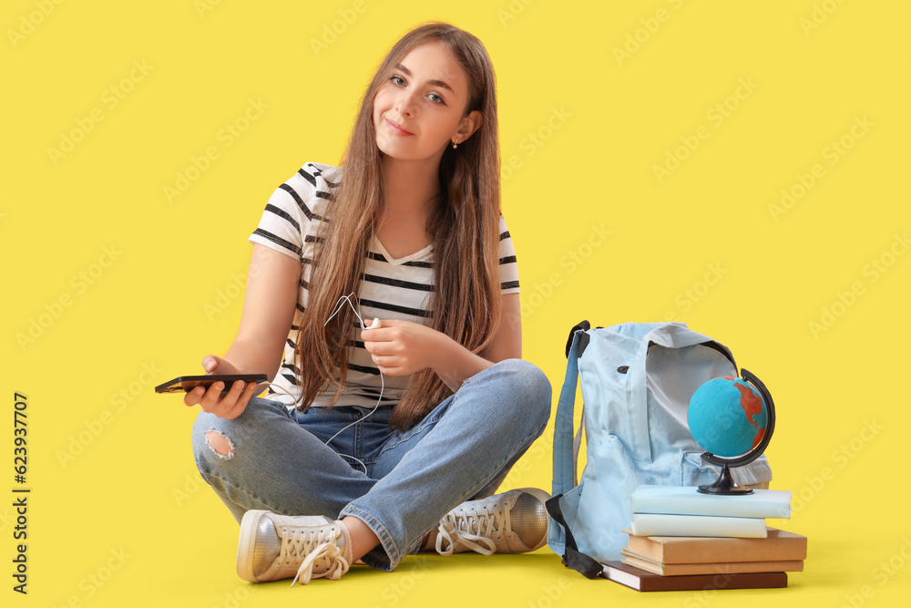 Sticker female student in earphones with mobile phone on yellow background