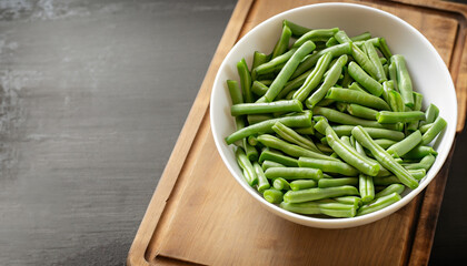 Green beans in white bowl on cutting board.