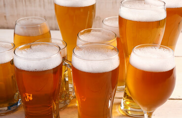Glasses of cold beer on light wooden background. Oktoberfest celebration