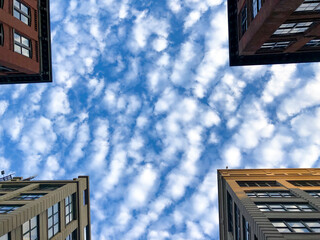 Clouds between four buildings, low angle view. - 623945727