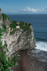 Cliff on the coast of the Indian Ocean of the island of Bali. Indonesia. Steep rocks on the coast.
