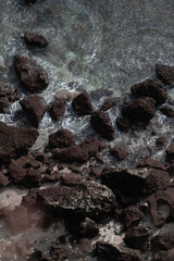 The waves of the ocean water meet with underwater pointed rocks