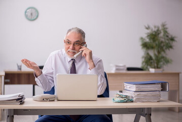 Old male employee working in the office