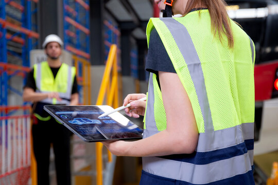 Young caucasian engineer woman using digital tablet and man or worker checking electric train for planning maintenance in station, transport and infrastructure, inspector check service transport.
