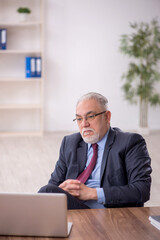 Old male boss employee working in the office