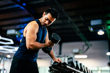 Young Asian Man Working Out with Dumbbell in a Vibrant Gym - Fitness and Wellness Concept for Active Lifestyle