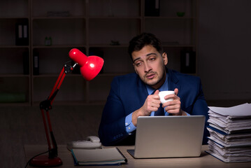 Young male employee working late in the office