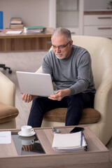 Old male employee working from home during pandemic