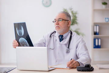 Old male doctor radiologist working in the clinic