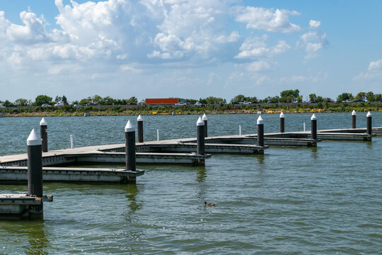 Empty floating boat slips and wooden dock at a calm marina under a cloudy sky