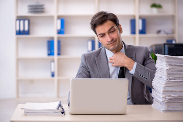 Young male employee and too much work in the office