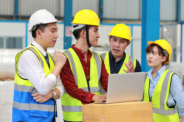 Group of technician engineer and businessman in protective uniform standing and discussing, researching, brainstorming and planning work together with computer at industry manufacturing factory