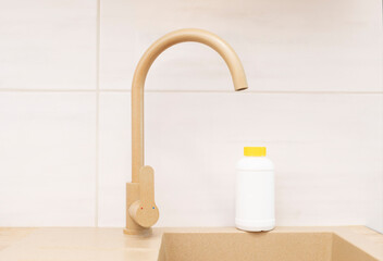 Pipe Drain Granules in White Plastic Bottle With Yellow Cap On Kitchen Sink In Cook Room. Clog...