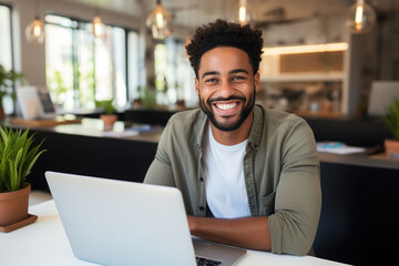 Fototapeta premium Smiling of young black freelancer use the laptop in the cafe