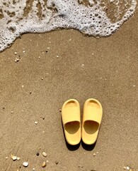 Fototapeta na wymiar yellow sandals on the beach
