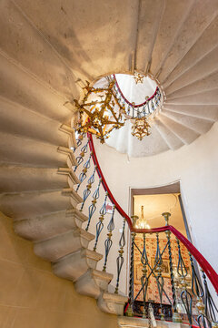 Duino, Italy - August 24, 2008: Spiral staircase in the Duino Castle, with wrought iron railings and lamps.