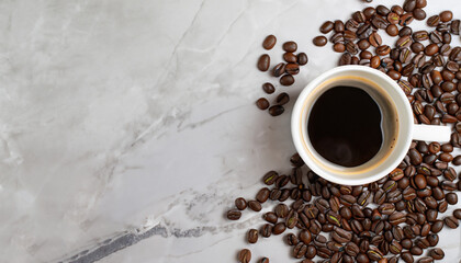 Cup of black coffee with coffee beans on marble table. Copy space. Top view.