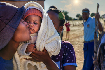 village african family, sisters holding baby brother