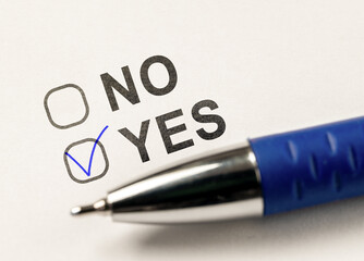 Check boxes yes or no on white paper. checkbox YES. marked with tick mark and blue pen on white...