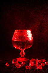 Glass with cognac and ice on a dark background. the concept of alcoholism and drinking