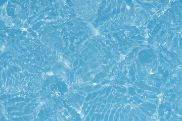 Fototapeta na wymiar Blue water with ripples on the surface. Defocus blurred transparent blue colored clear calm water surface texture with splashes and bubbles. Water waves with shining pattern texture background.