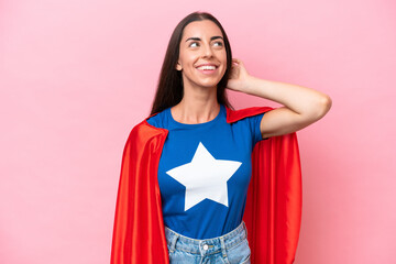 Super Hero Caucasian woman isolated on pink background thinking an idea