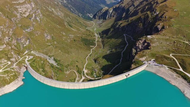 Moiry, Switzerland: Aerial drone footage of the Moiry dam above the Grimentz village in the Anniviers valley in Canton Valais in the Swiss alps in summer. Shot with a backward motion. 