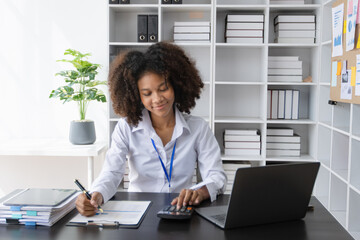 Young African American businesswoman cheerfully celebrate success at office desk in office, analysis data the charts, online tired, business finance and accounting concept.
