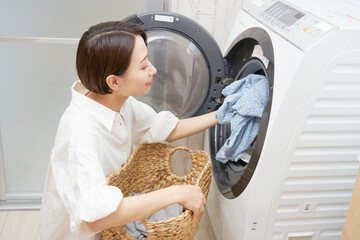 洗濯機から洗濯物を取り出すミドルエイジの女性