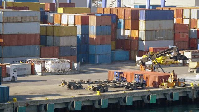 4K footage showing lorry and cargo trailer passing by container. Colorful shipping containers stacked at commercial port stock video.	