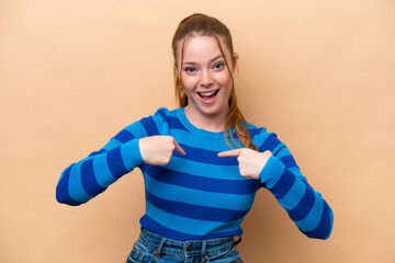 Young caucasian woman isolated on beige background with surprise facial expression
