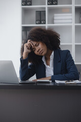 Young African American businesswoman are stressed and tired from work sitting at desk in the office, feeling sick at work, stress from work.	