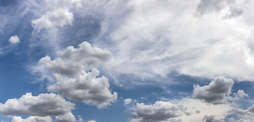 white fluffy clouds and blue sky. panoramic view during summer time.