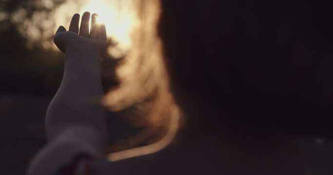 Woman hand reaching for the sun
